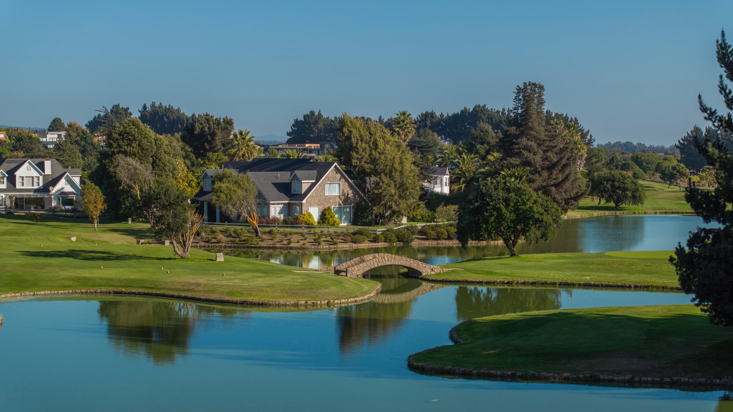 Casas y puente sobre la laguna del campo de golf del condominio